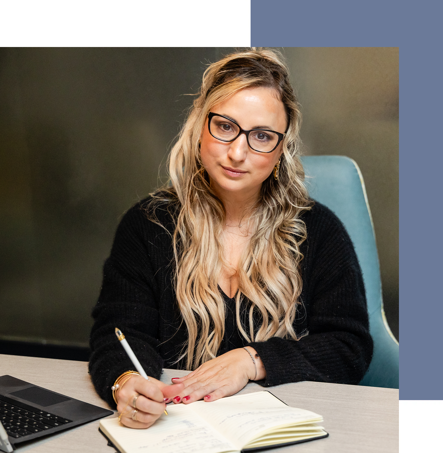 A woman sitting at her desk writing in a notebook.