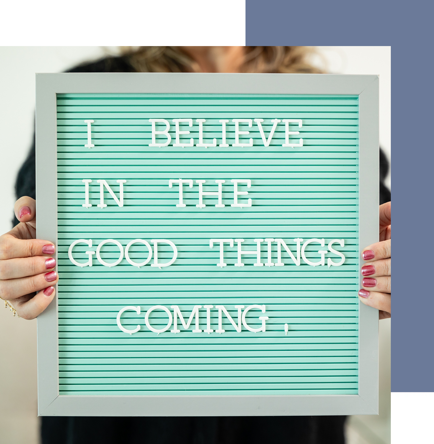 A person holding up a sign that says " i believe in the good things coming ".