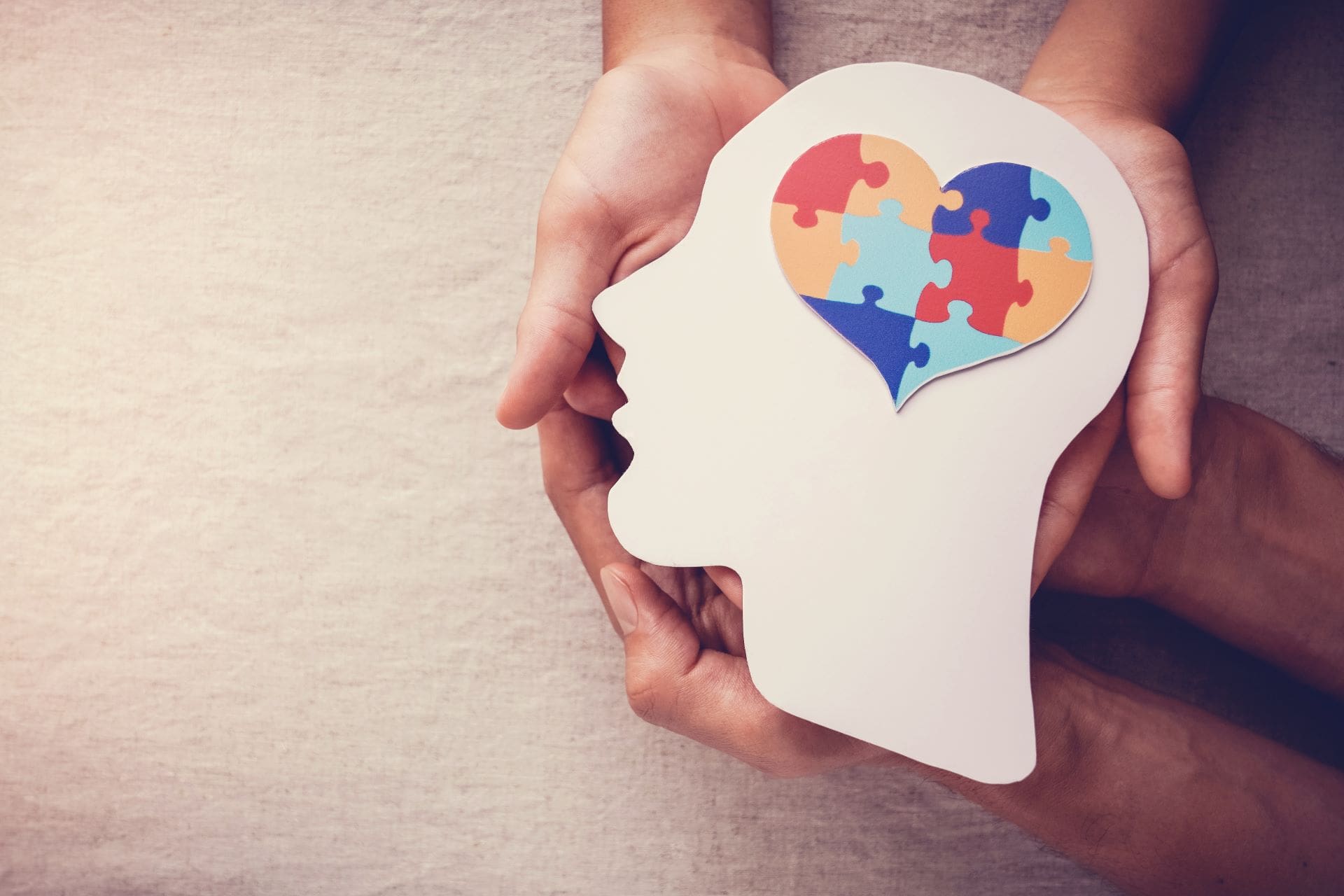 A person holding a puzzle heart in their head.