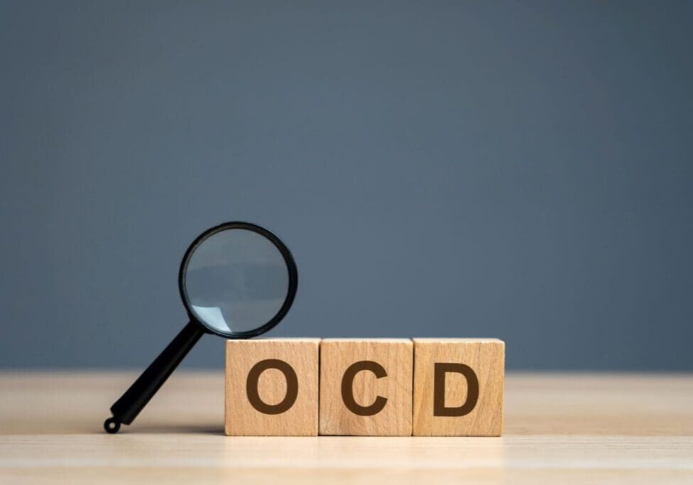 A magnifying glass sitting on top of blocks that spell " ocd ".