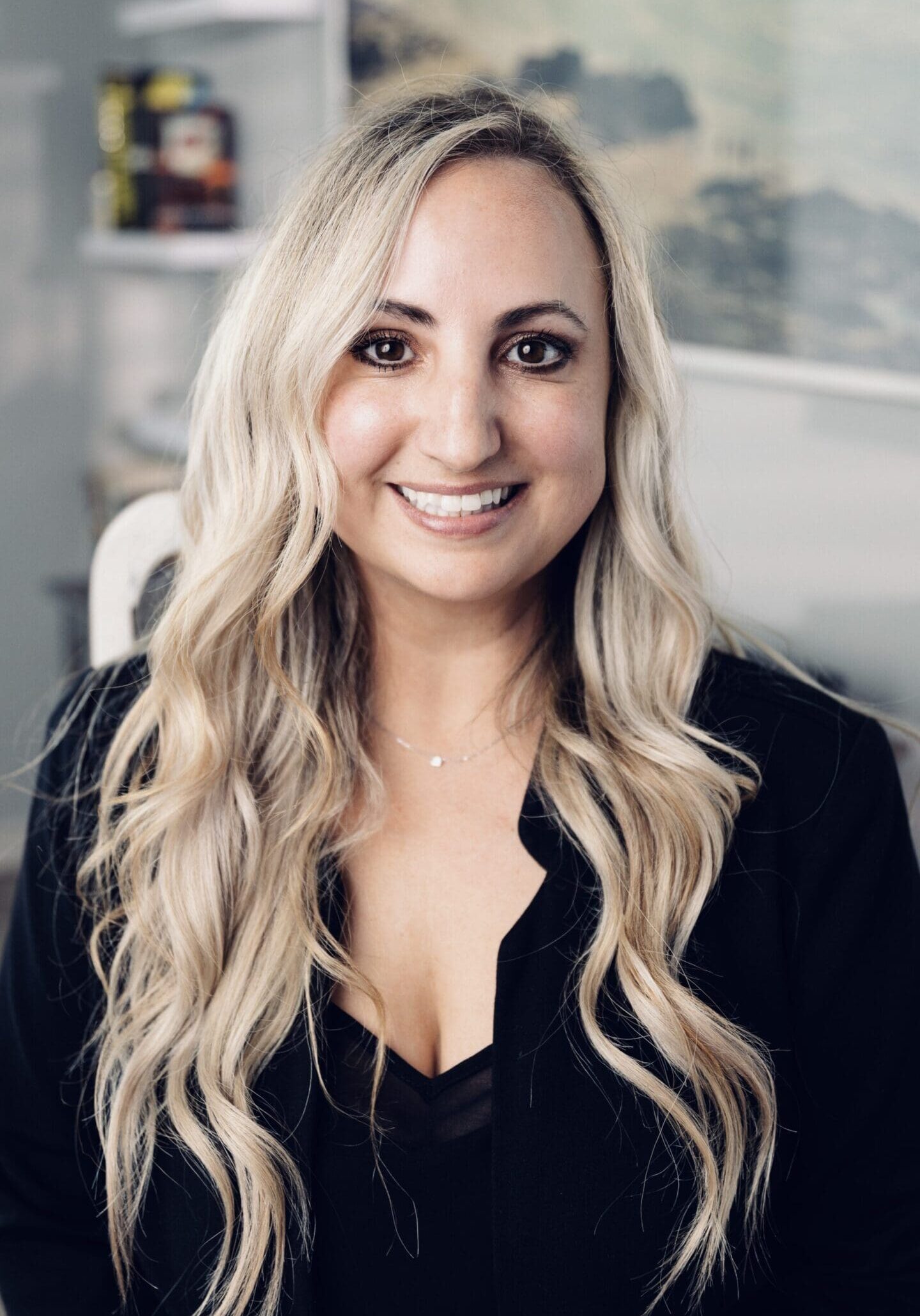 A woman with long blonde hair wearing black shirt.